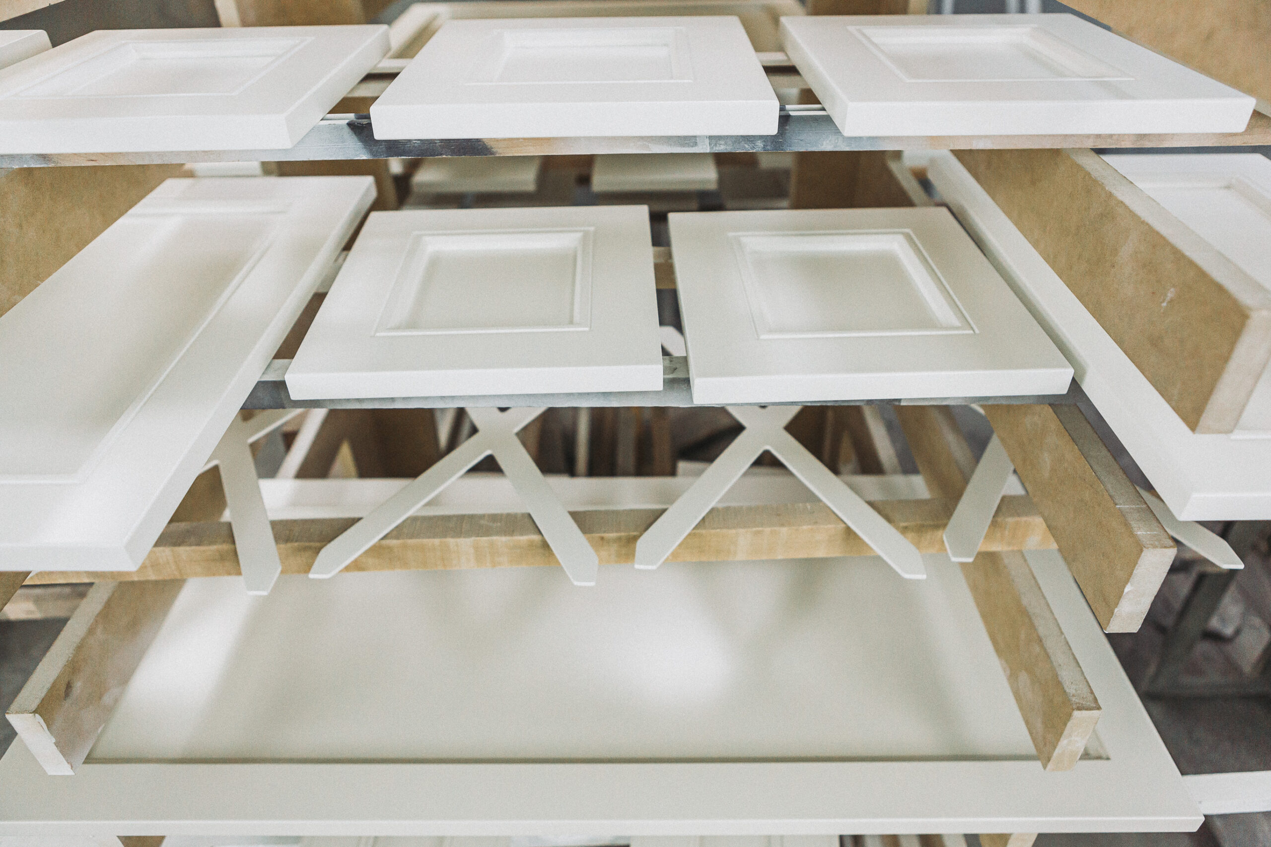 A well-organized workshop showcases pristine white wooden components, ready for crafting high-quality furniture.