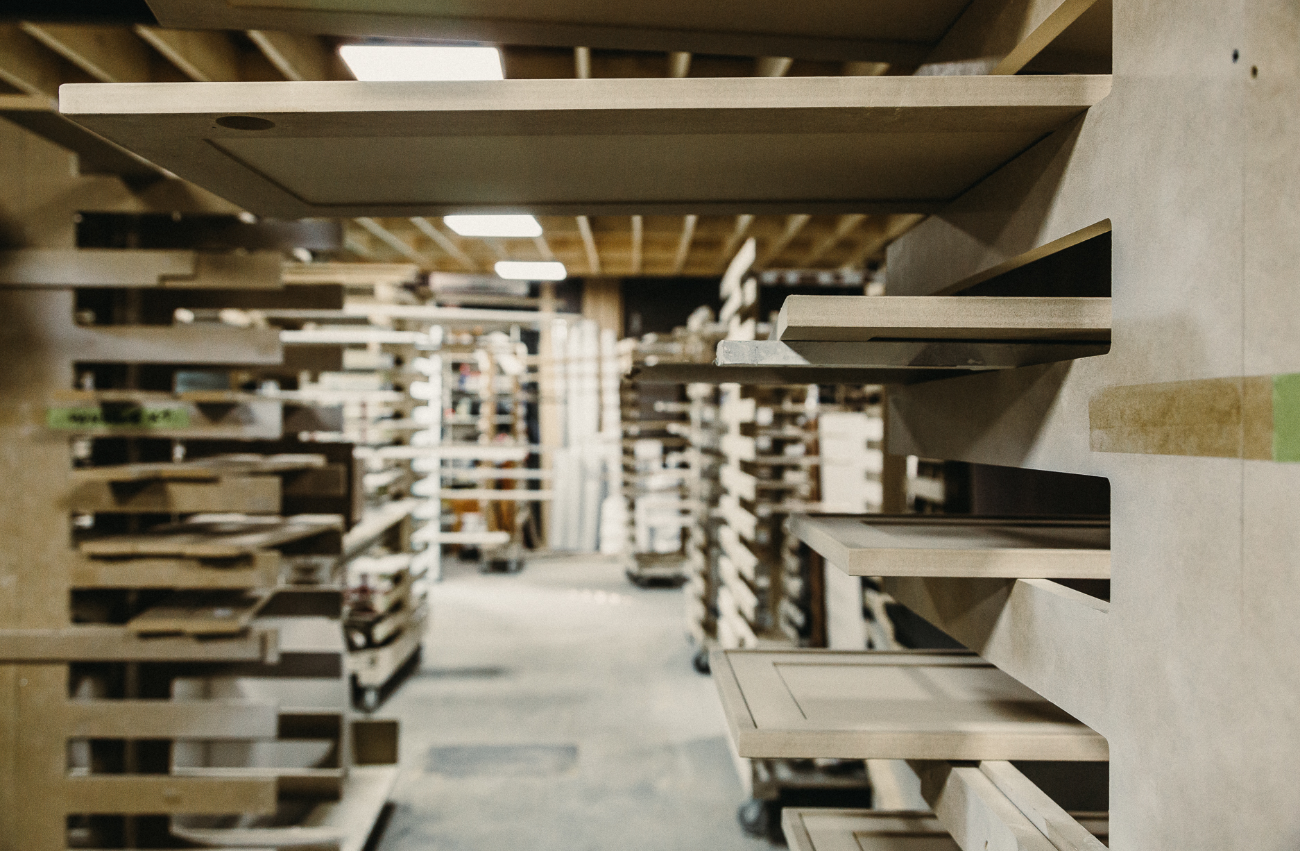 Organized woodworking workshop filled with neatly stacked wooden panels, showcasing a functional and inviting workspace for creative projects.