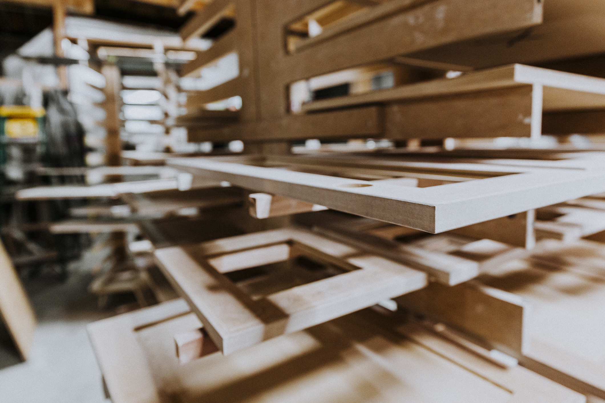Neatly stacked wooden sheets in a warm woodworking shop highlight the artistry and craftsmanship of skilled artisans.