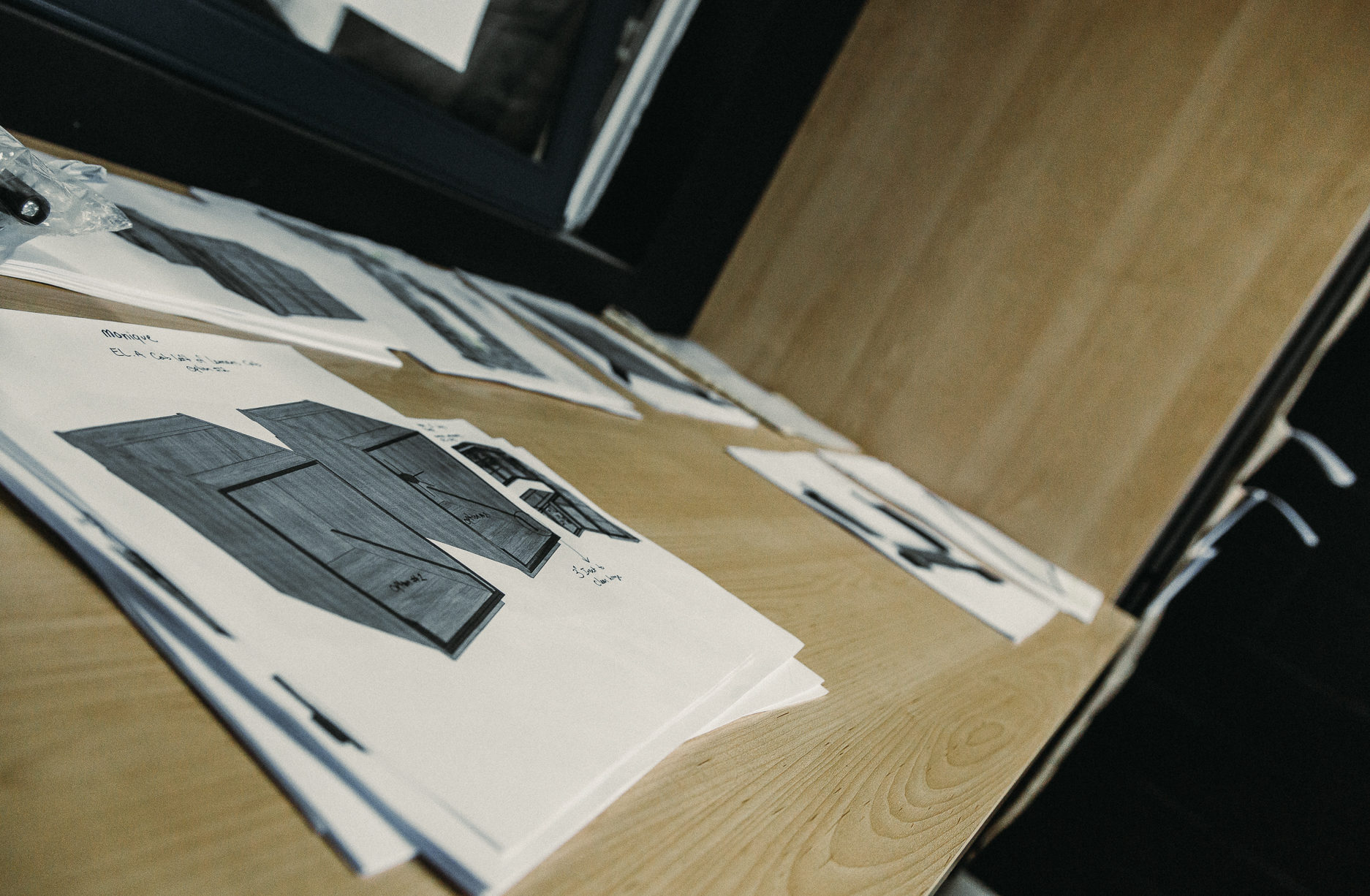 Organized design drafts on a modern workspace table showcase a creative and collaborative project in progress.